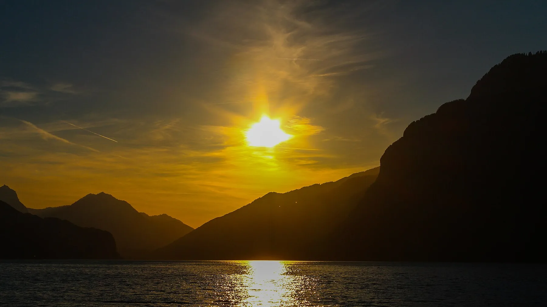 Abendsonne über dem Walensee: die Bergflanken als Silhouette, die Sonnenspur auf dem Wasser